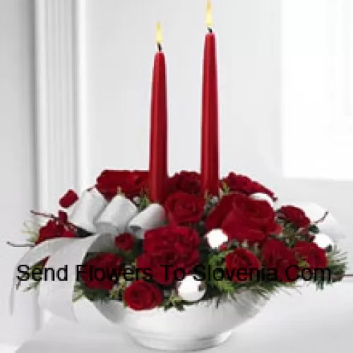 Our Holiday Elegance Centerpiece will add that special spark to their seasonal celebration with its vibrant array of crimson blooms! Red roses, carnations and spray roses sit amongst holiday greens in a posh ceramic?silver container adorned with a beautiful silver ribbon accent and two taper candles to bring a holiday glow of warmth and peace to their table. (Please Note That We Reserve The Right To Substitute Any Product With A Suitable Product Of Equal Value In Case Of Non-Availability Of A Certain Product)